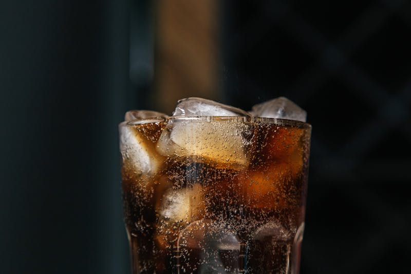 Classic soft drink soda in a glass with ice